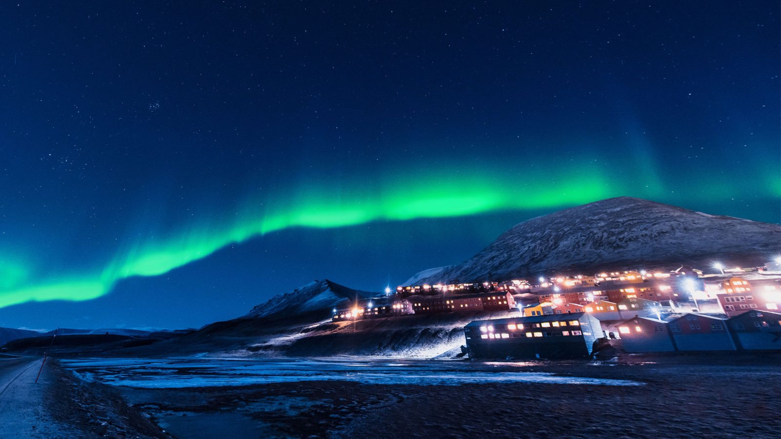 Northern lights over the snow-covered town of Longyearbyen, Svalbard, Norway.