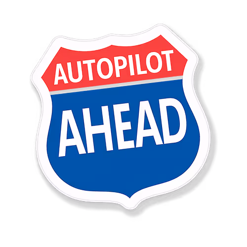 Shield-shaped road sign with red top reading 'AUTOPILOT' and blue bottom reading 'AHEAD'.