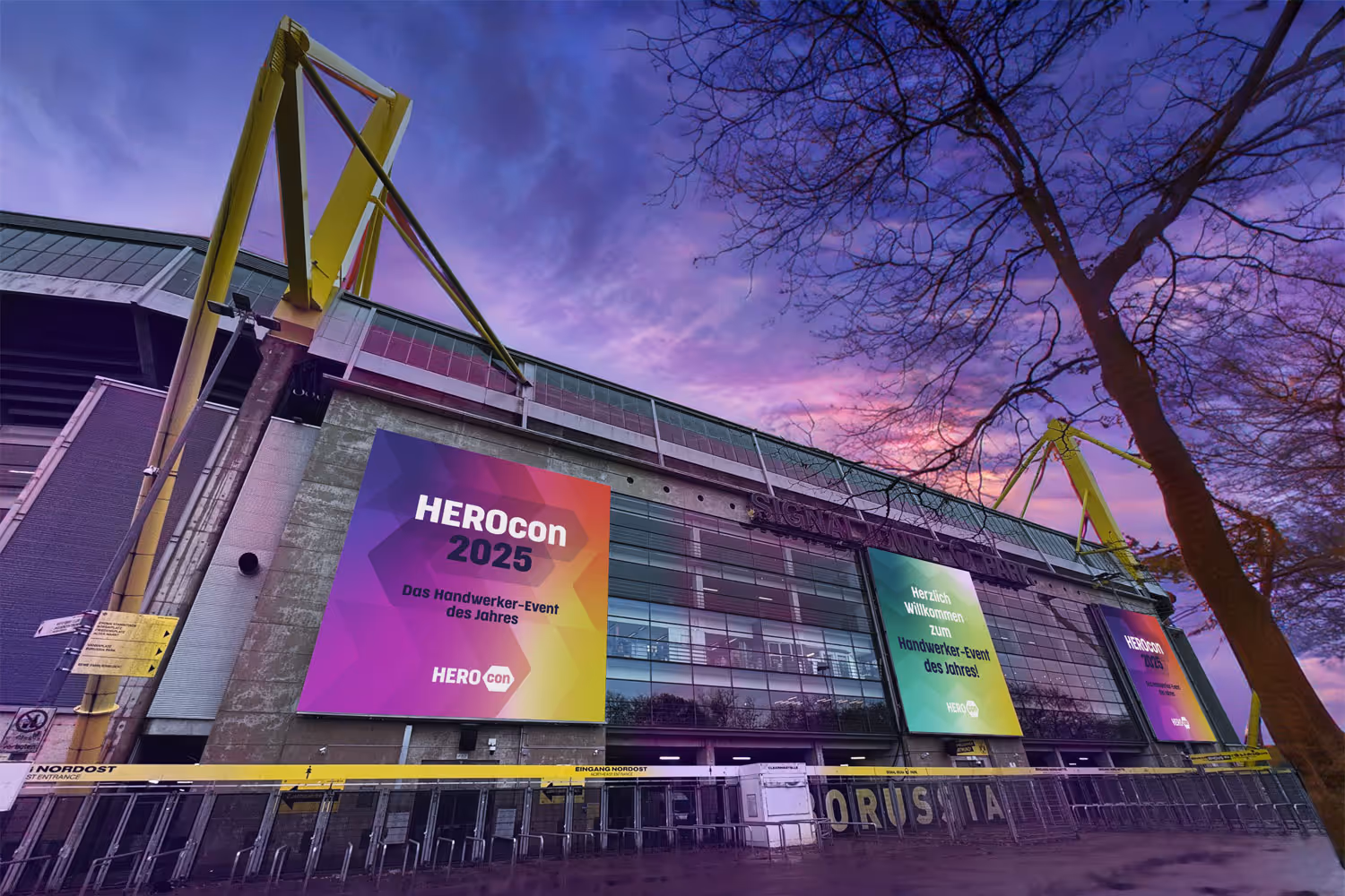 Signal Iduna Park mit großen HEROcon-2025-Bannern vor violett-pinkem Abendhimmel.