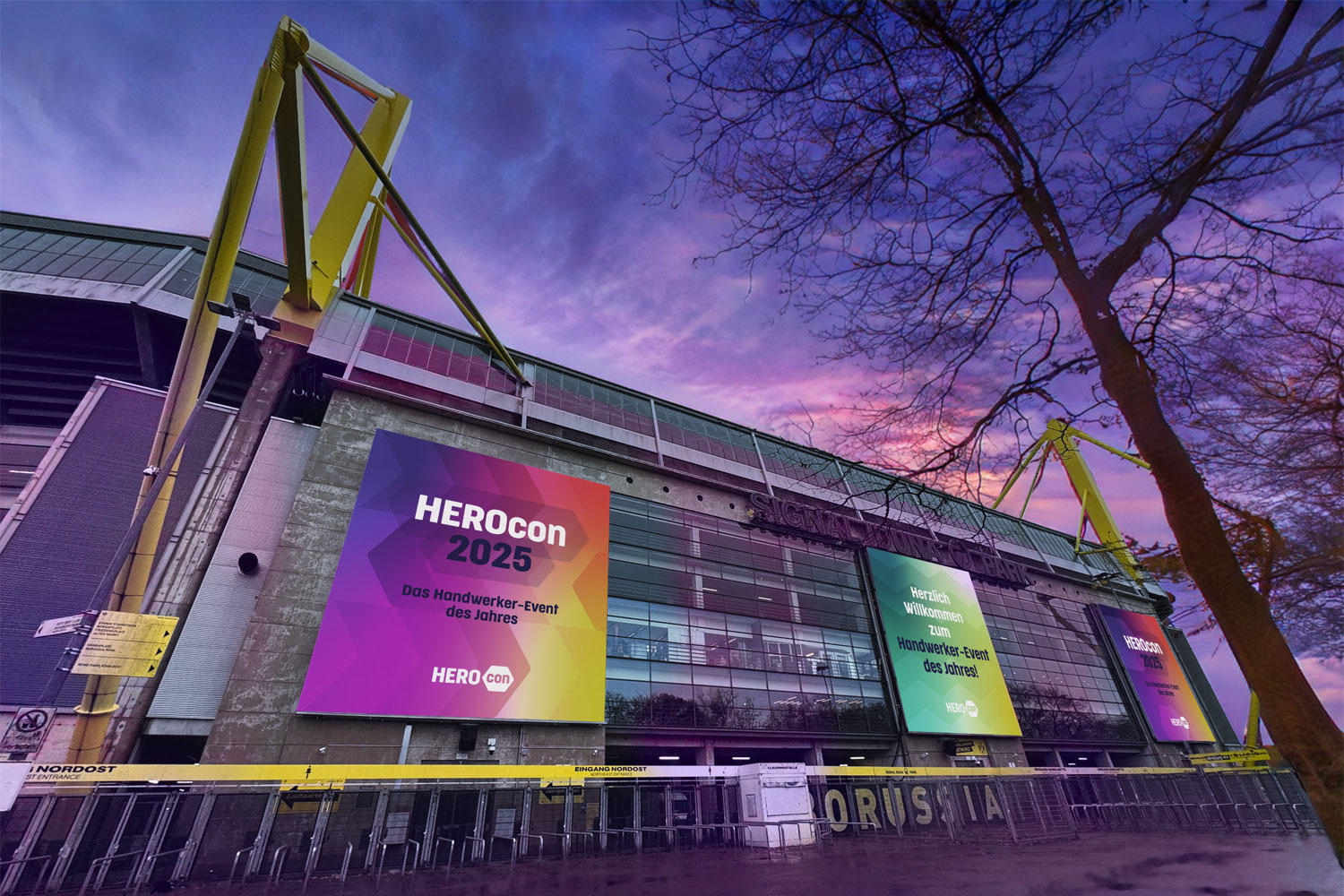 Signal Iduna Park mit großen HEROcon-2025-Bannern vor violett-pinkem Abendhimmel.
