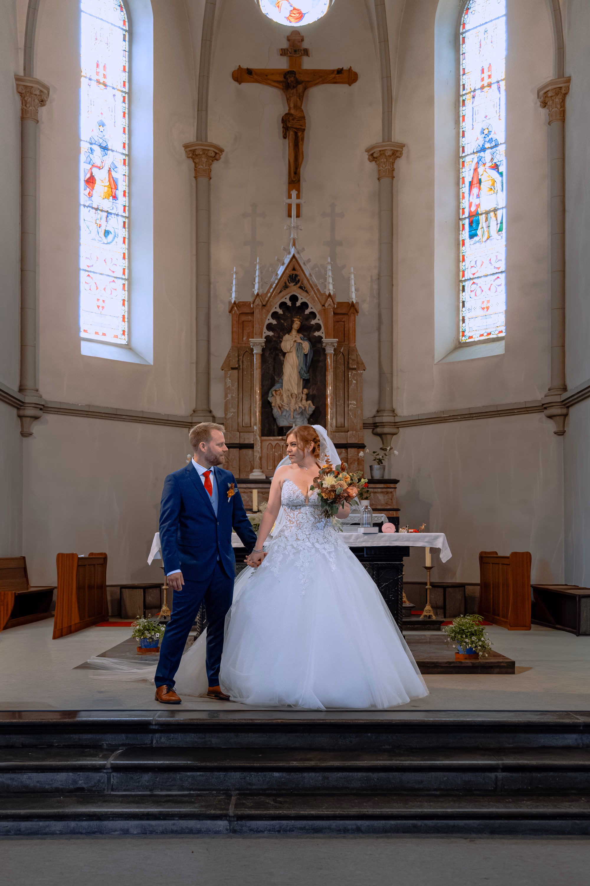 Couple de mariés devant l’autel de l’église de Vionnaz pendant leur cérémonie religieuse