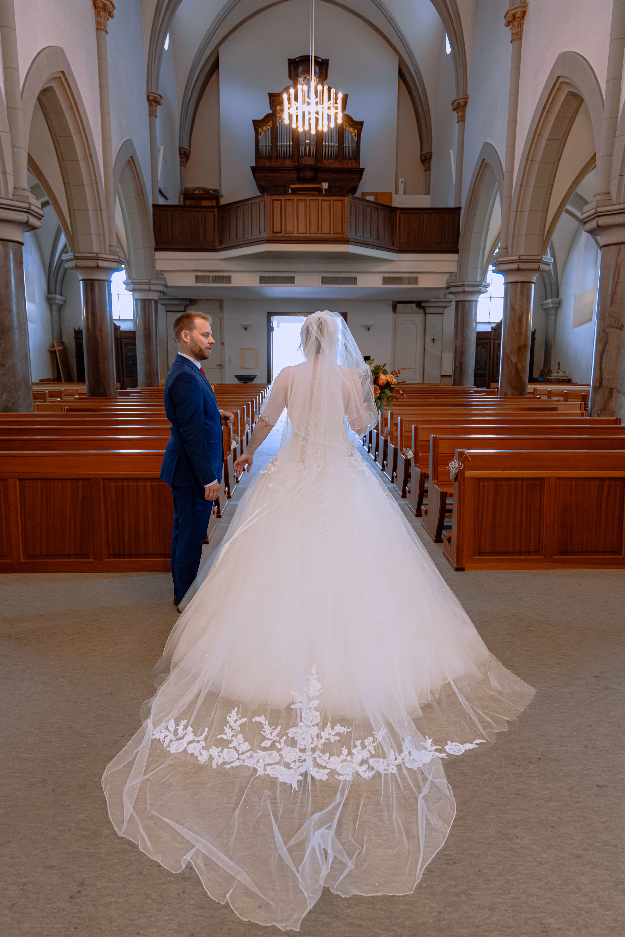 Portrait des mariés dans l’église de Vionnaz avec vitraux et architecture néo-gothique