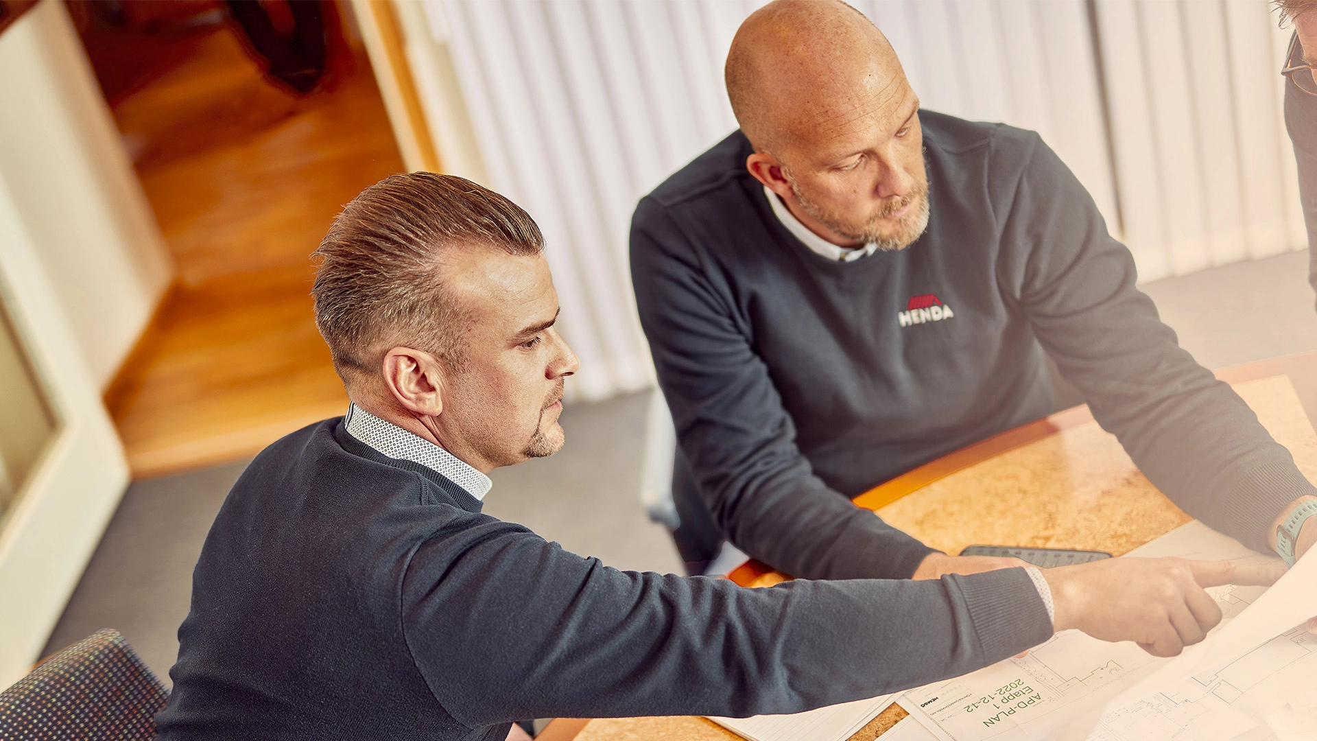 ["Olika företagsledare granskar papper och dokument vid ett konferensbord i trä och planerar strategiska tillväxtinitiativ tillsammans effektivt."]