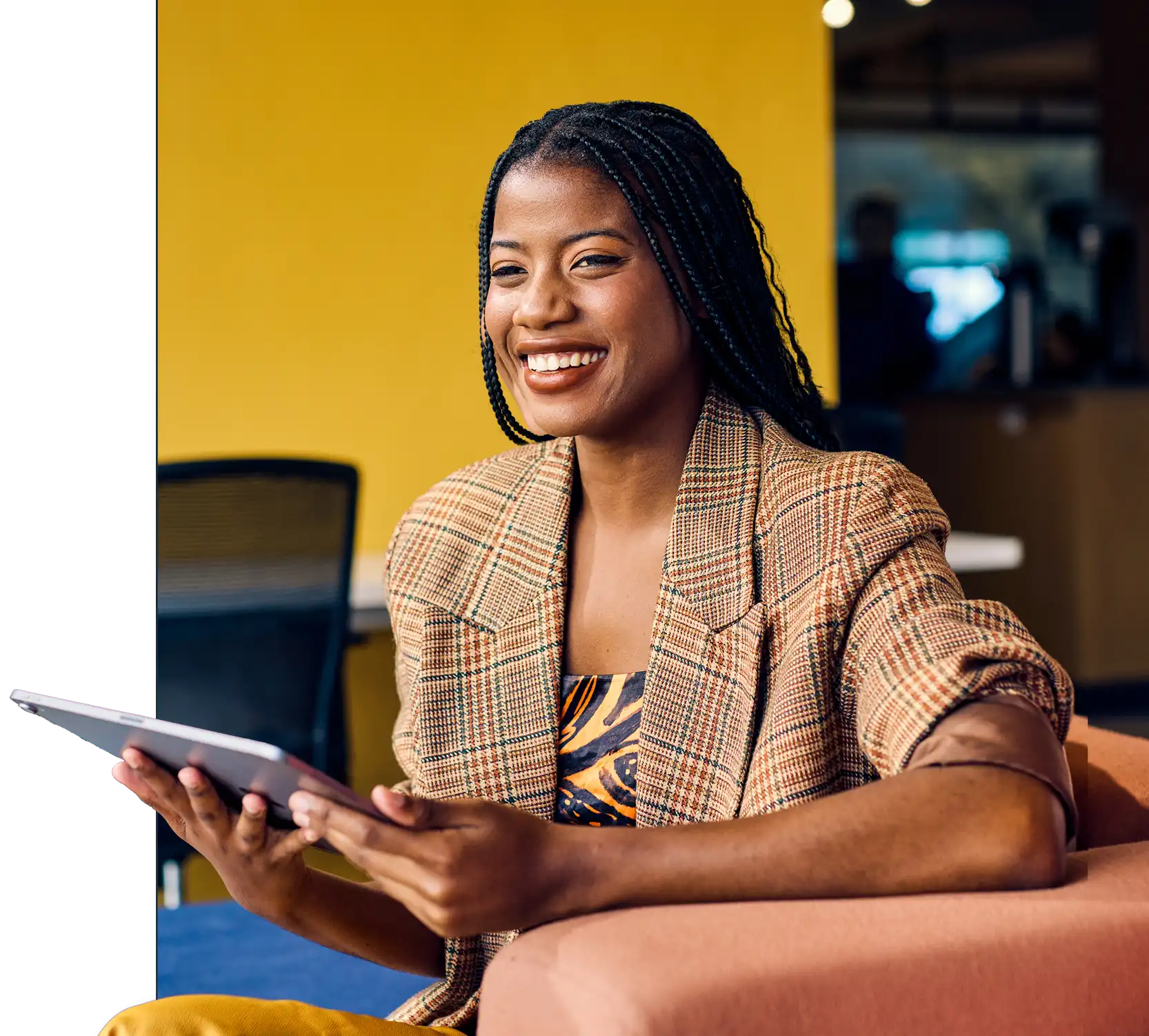Smiling professional woman holding a tablet in a modern office setting