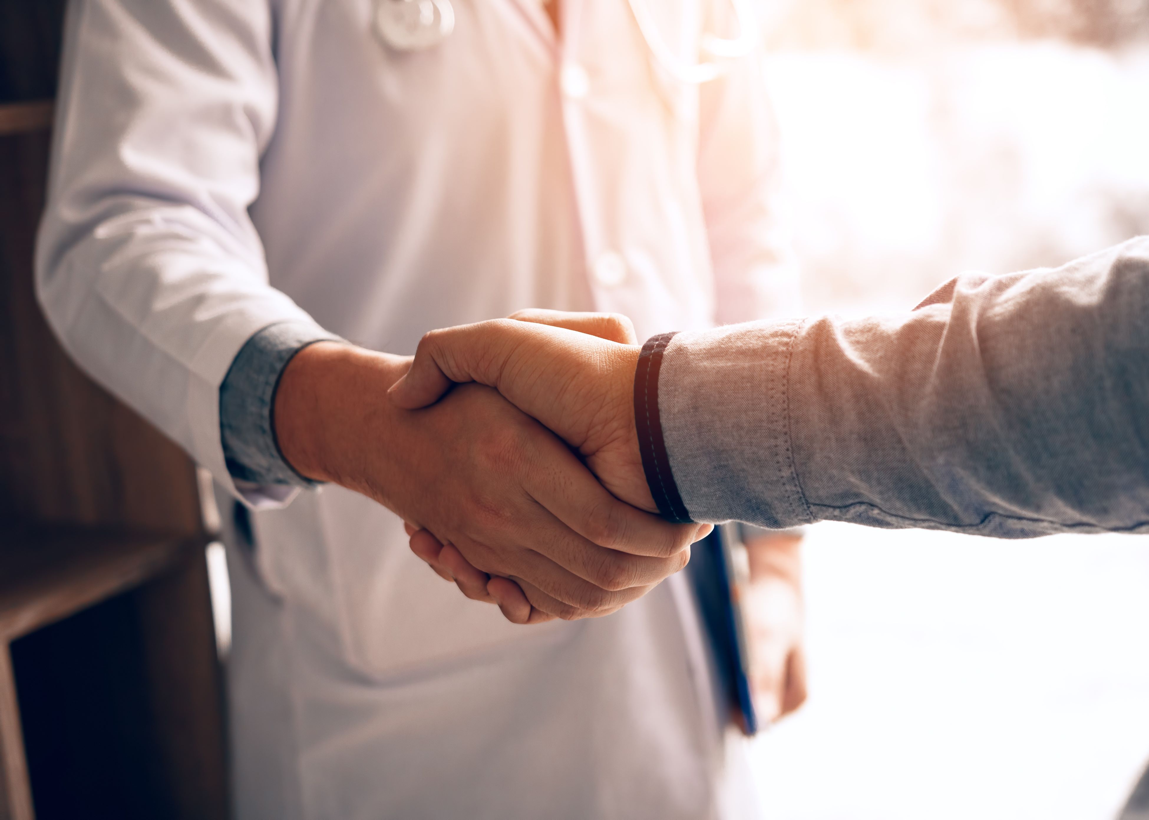 Two people shaking hands in a room.