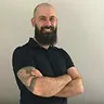 Portrait of Milko Slavov with arms crossed and a confident smile, representing his leadership in tech teams.