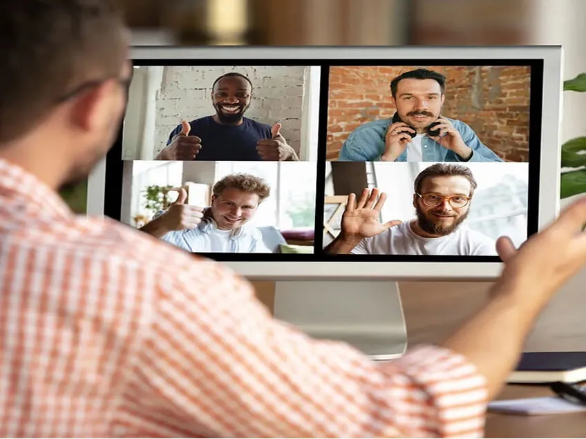 Person on a video conference call onscreen with four colleagues, illustrating remote-first work.