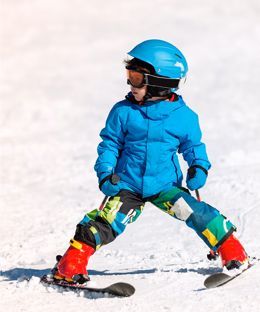 Child skiing down a mountain on a sunny day