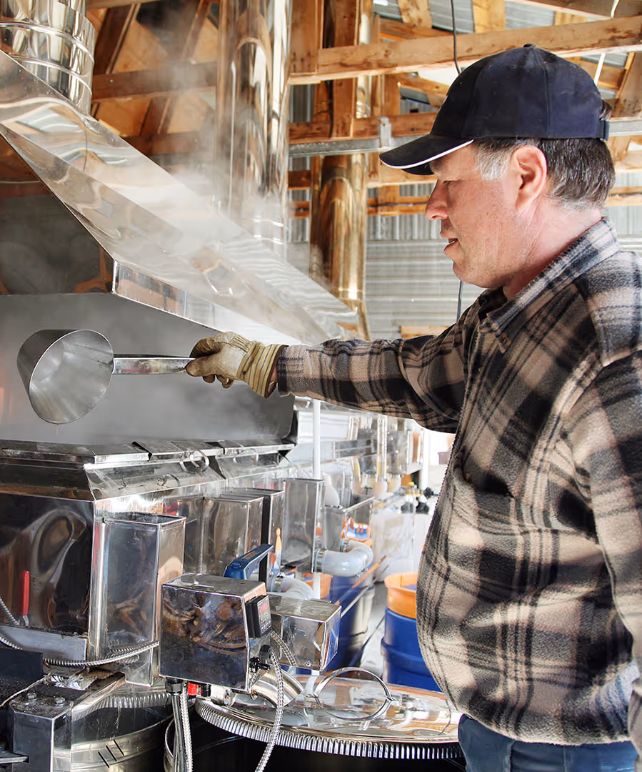 A man making maple syrup using machinery