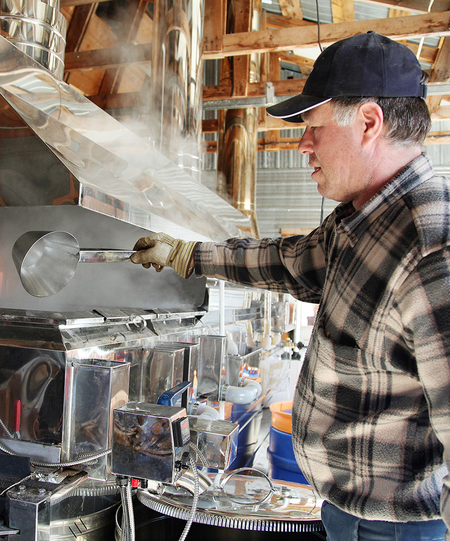 A man making maple syrup using machinery