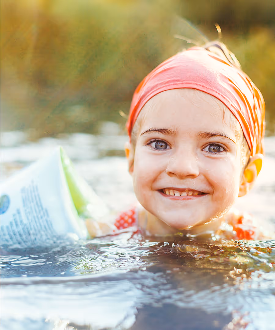 A young girl swimming with a floatie 