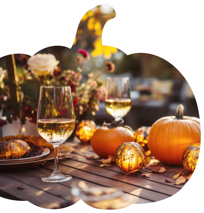a table with wine glasses and pumpkins