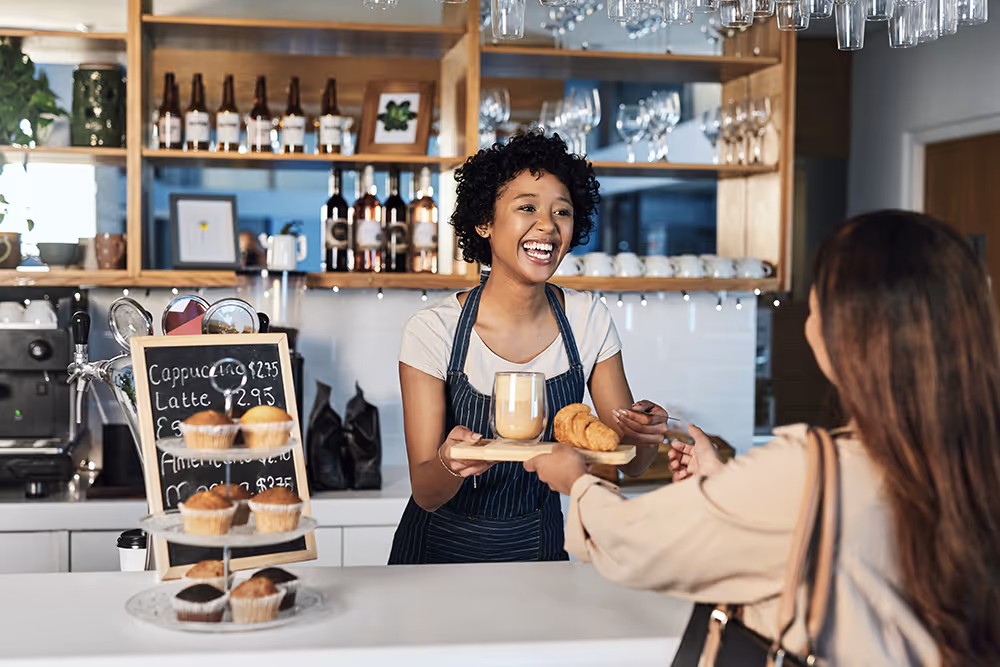 a woman handing a tray of food to a customer