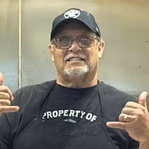 a man wearing a black hat and black apron