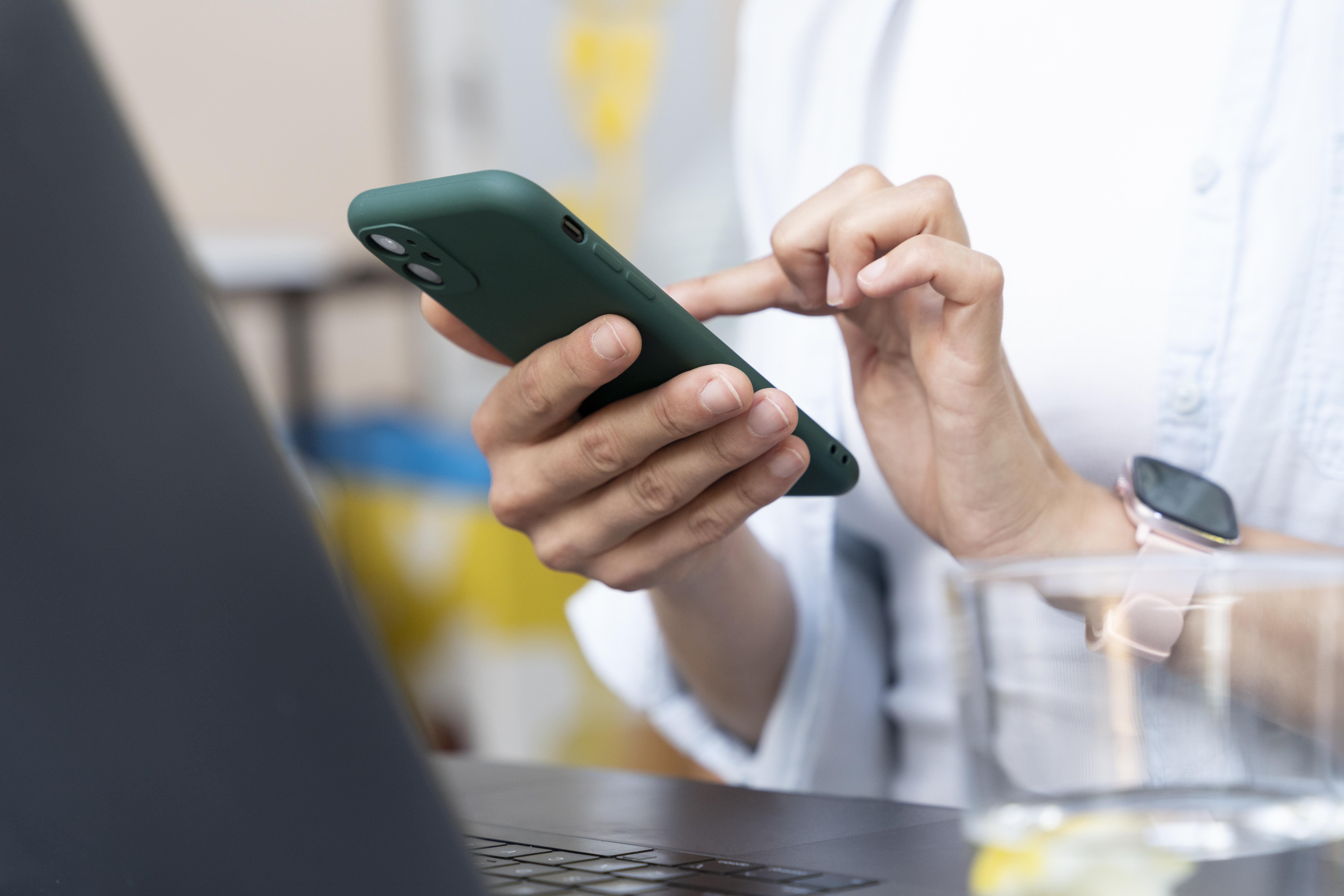 imagen de manos en celular- gracias por contacto avanza - venta y arriendo de bodegas industriales