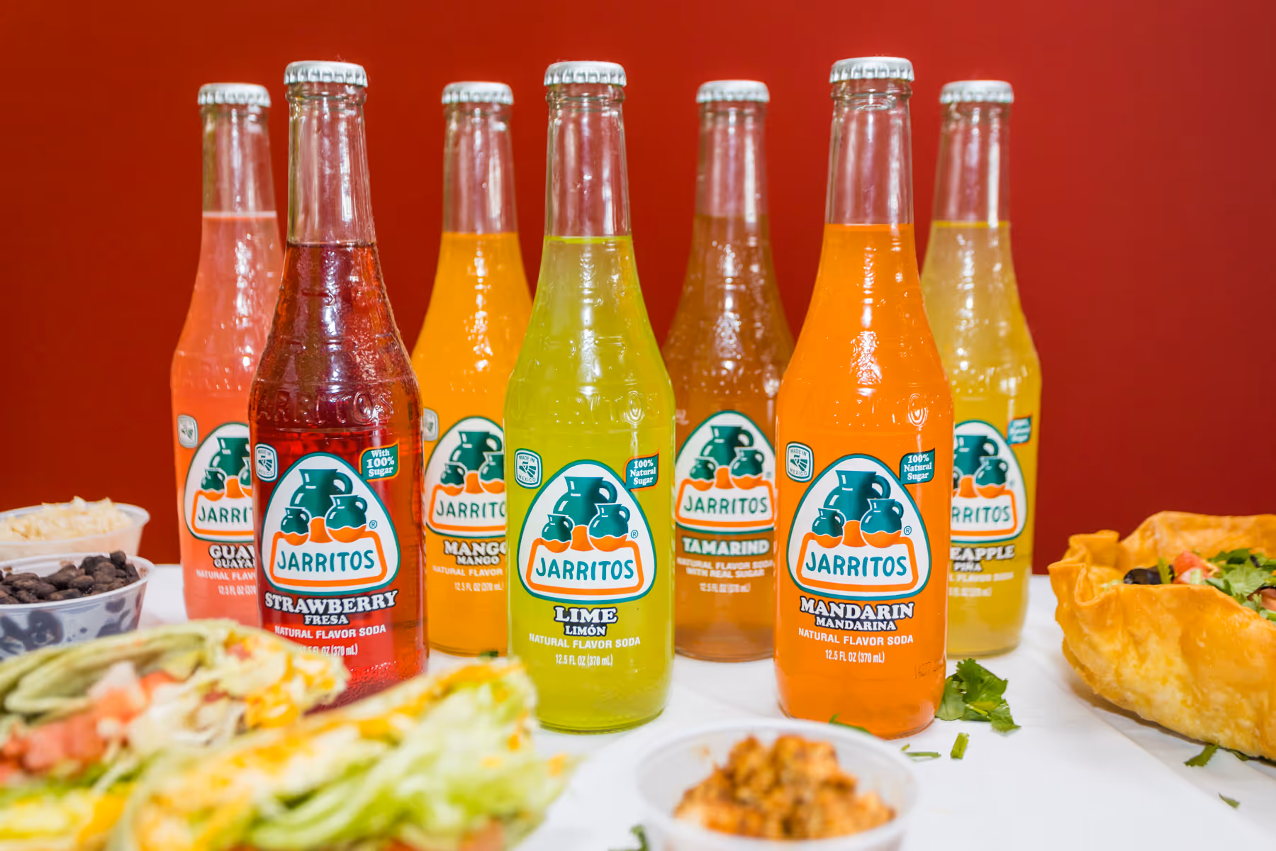 A table with a variety of bottles of Jarritos soda.