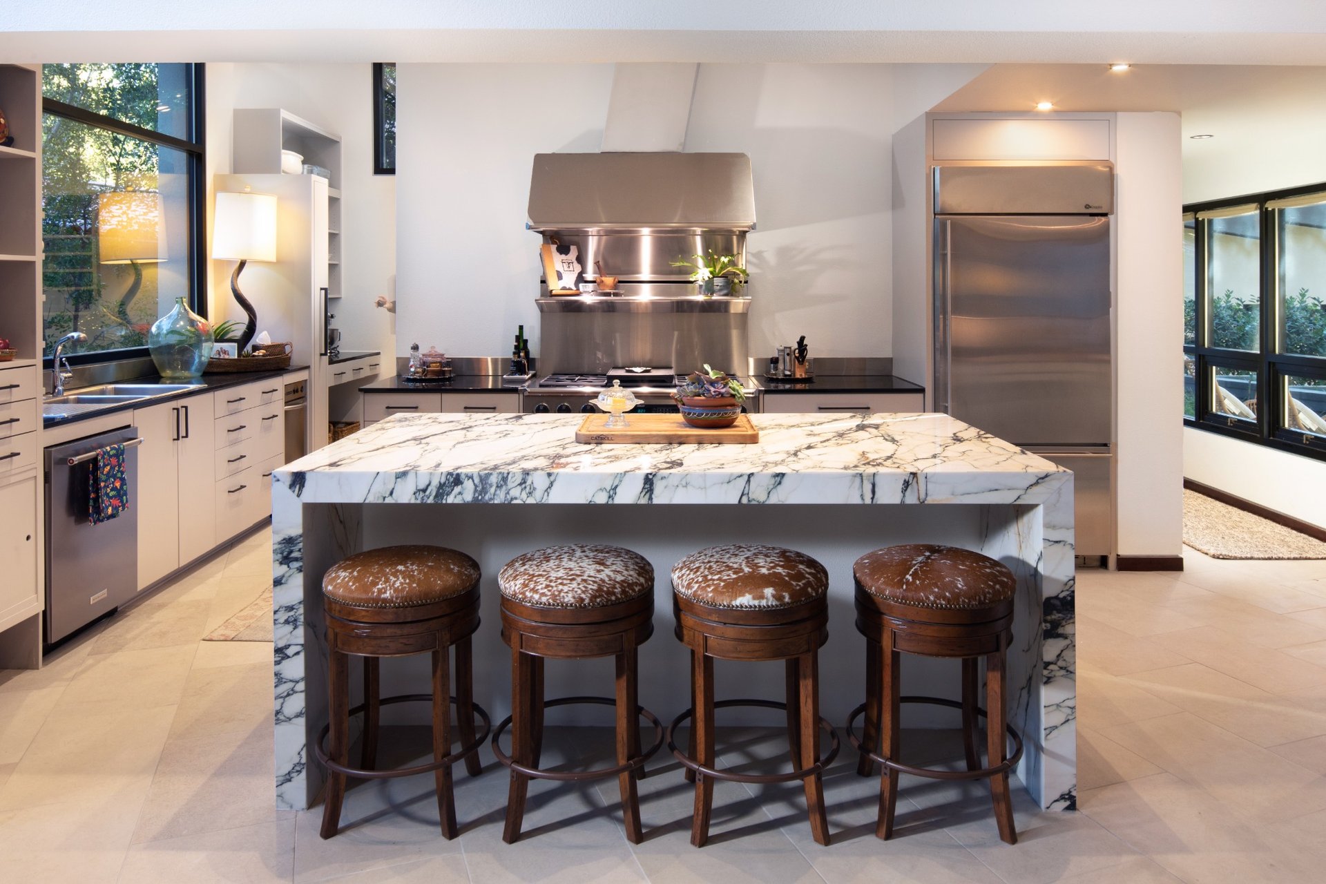 Luxury kitchen with waterfall marble island and stainless steel appliances in an Austin custom home.