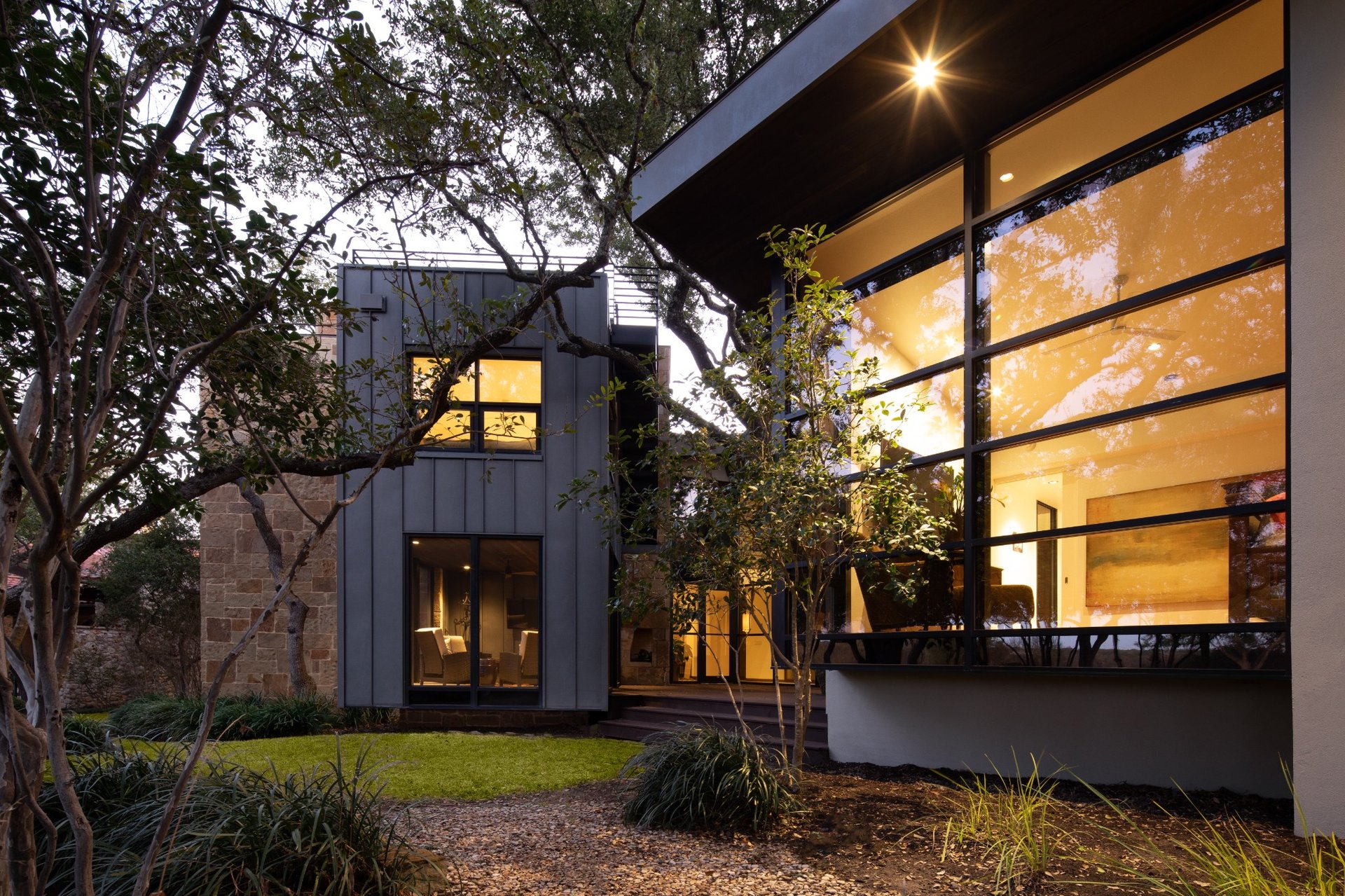 Contemporary Austin home with metal siding, expansive glass walls, and landscaped courtyard – designed and built by River City Construction and Design.