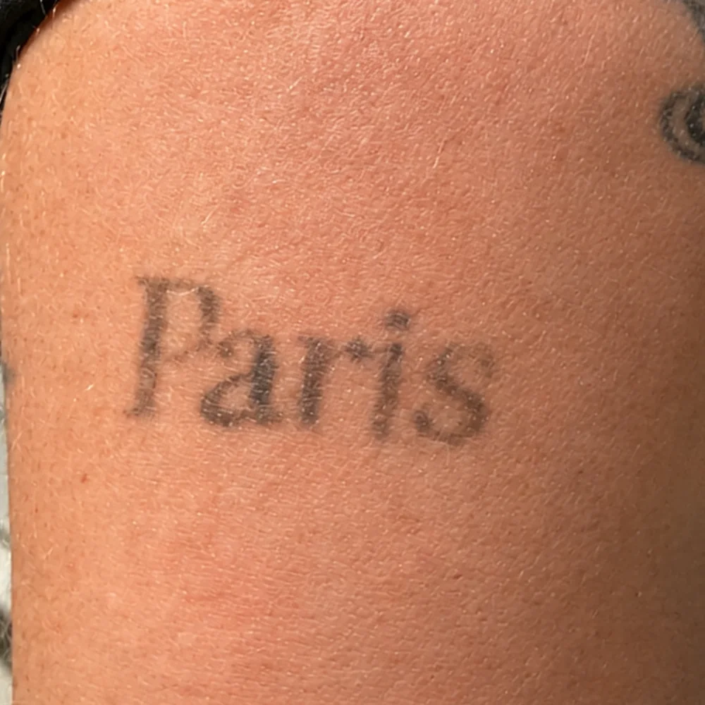 Même tatouage « Paris » après une séance de laser Discovery Pico, encre visiblement estompée
