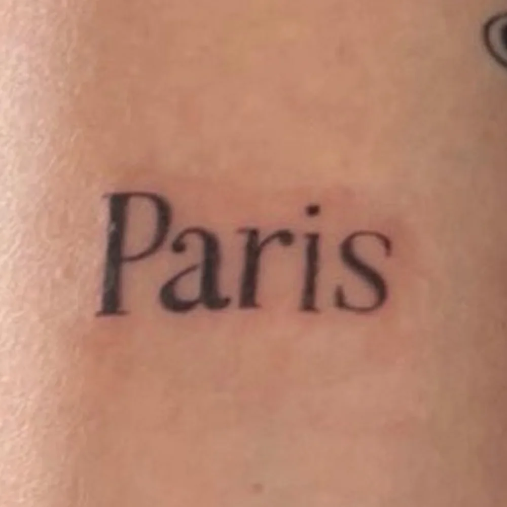 Tatouage lettrage « Paris » sur le bras avant détatouage laser chez obé studio à Marseille