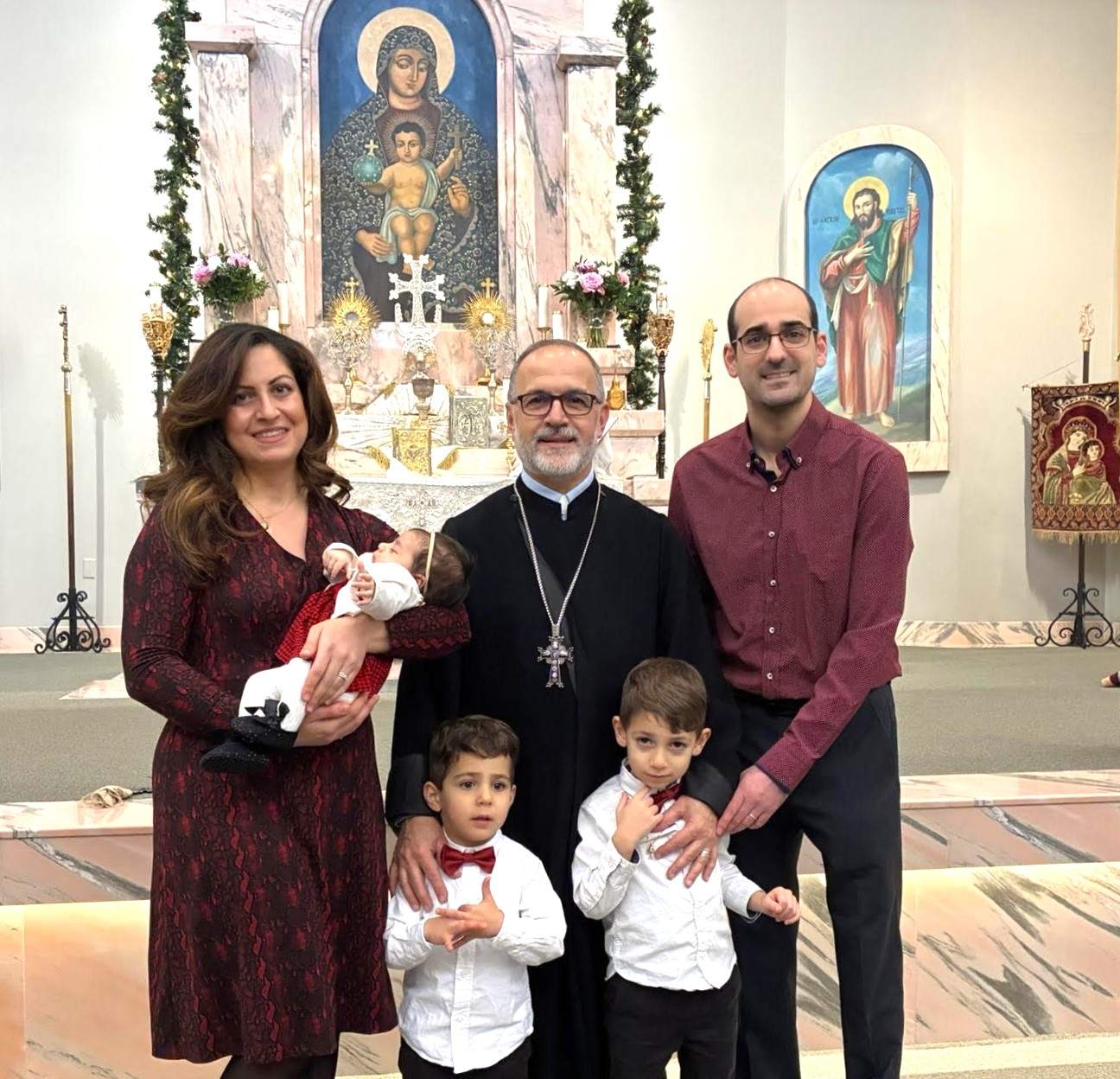 A funeral wreath of pink and white flowers with a ribbon reading “FROM VARTAN VARTANI AND FAMILY” inside Holy Trinity Armenian Church