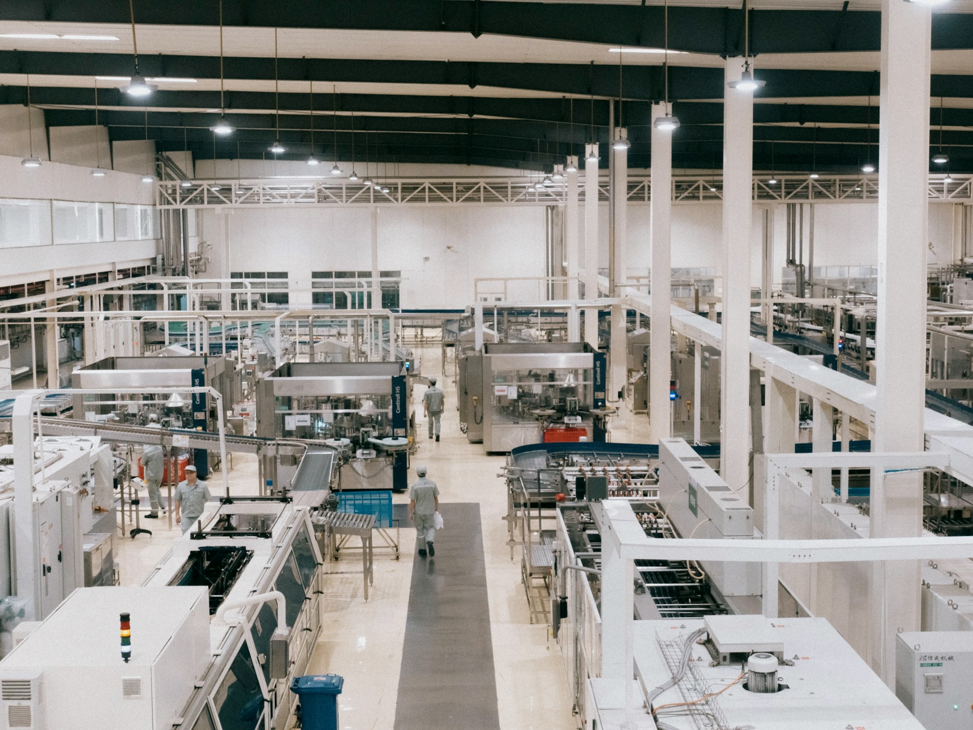 white manufacturing factory with people in the background