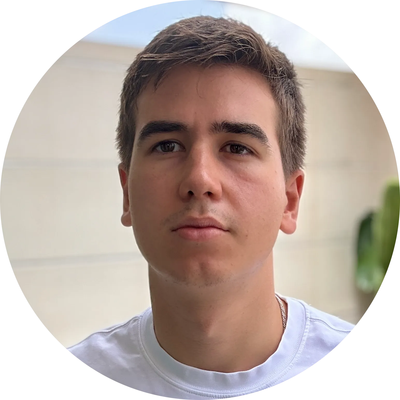 A headshot of Boris Vedernikov standing on the stone background in a white t-shirt