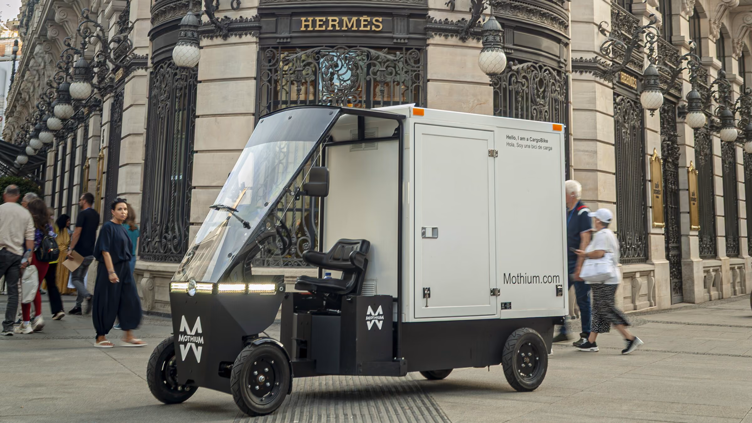 Mothium vehicle on a city street beside a historic building