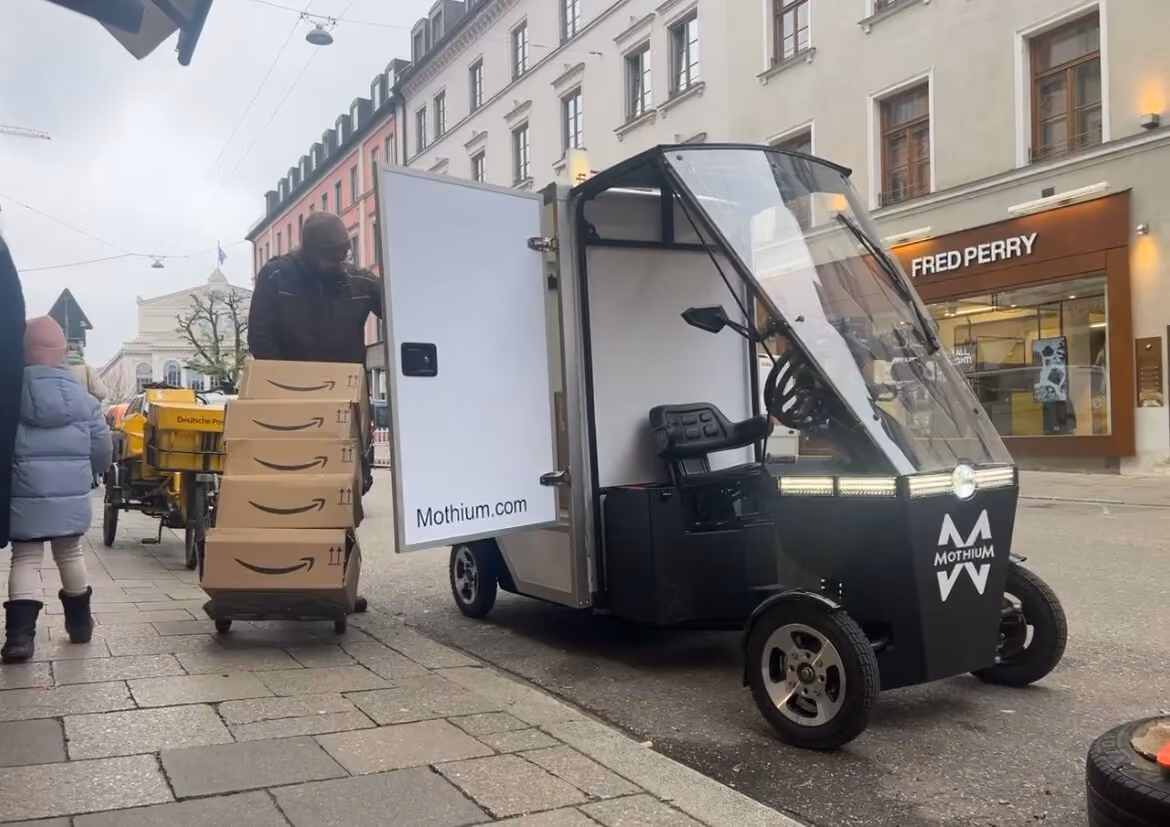 Courier unloading parcels from a Mothium vehicle on a pedestrian street