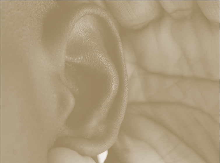 Close up image of someone cupping  their ear to hear better with a sepia filter