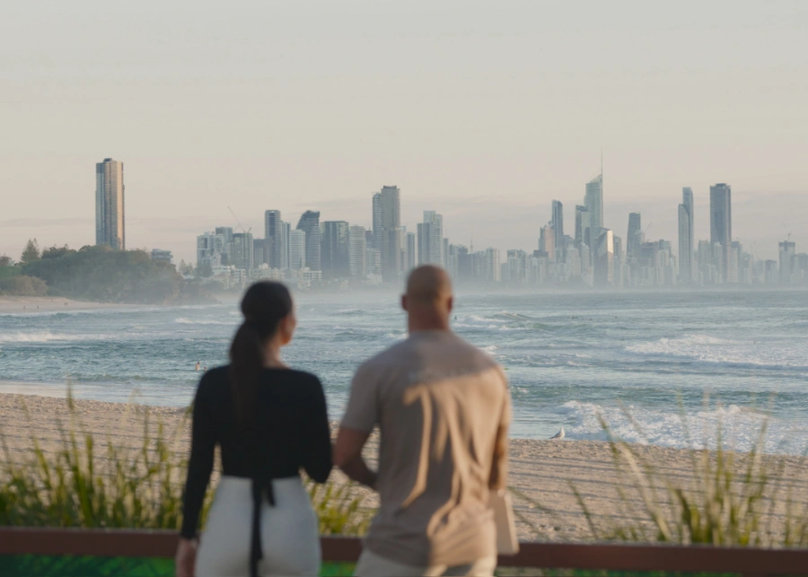 Tadhg Stephens and Heather Duffy exploring beachfront property options for owner-occupiers with city skyline view, Monarch Buyers Agents