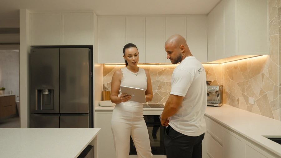 Tadhg Stephens and Heather Duffy reviewing property investment opportunities with Monarch Buyers Agents in modern kitchen setting