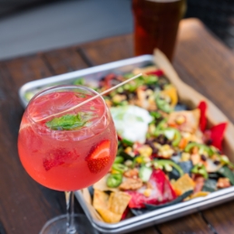 A cocktail and a plate of nachos