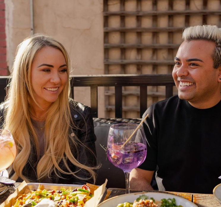 A couple of customers laughing together over cocktails