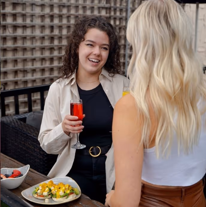 Two women chatting over cocktails