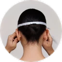 Person viewed from behind adjusting a white headband on short dark hair.