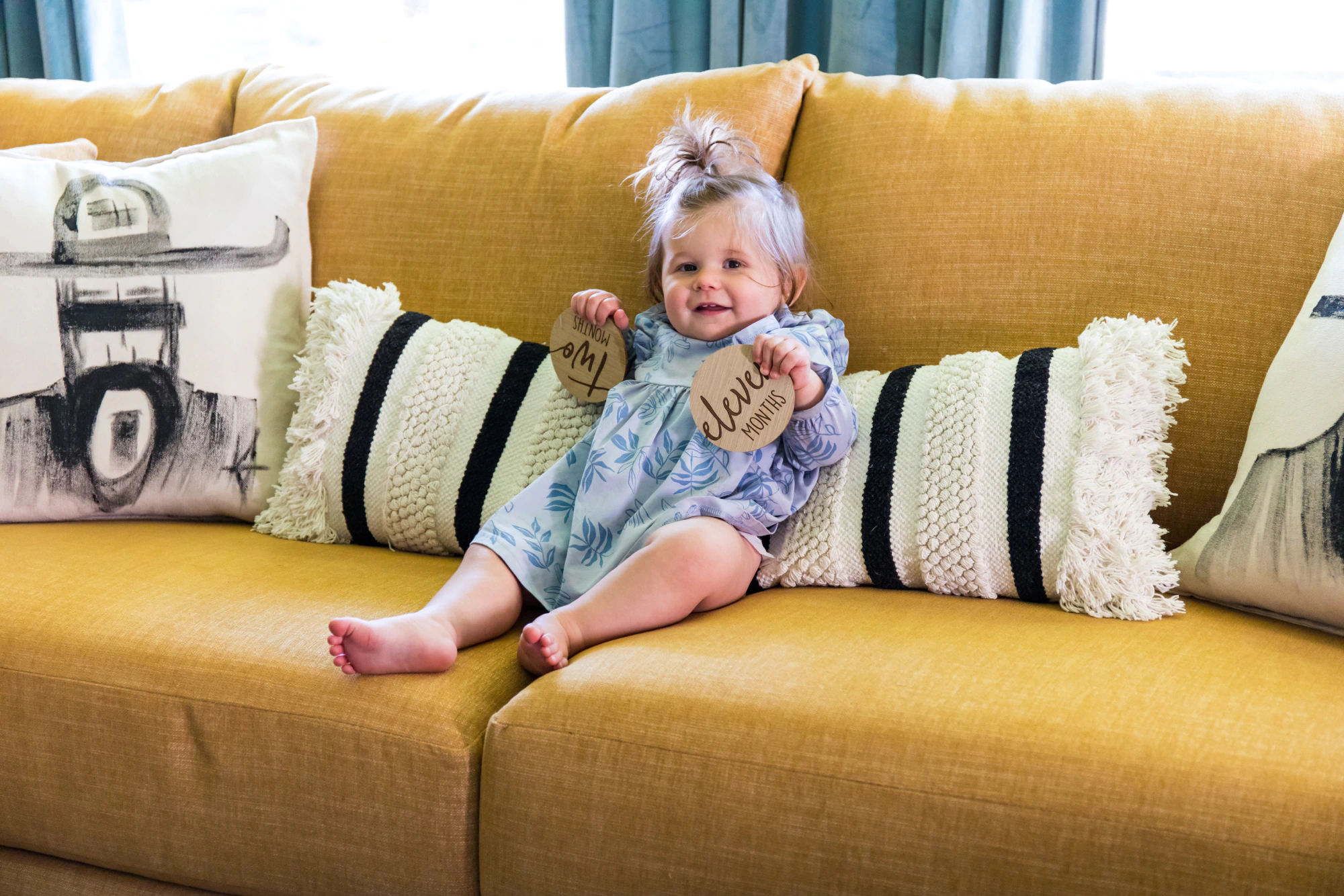 Child sitting on yellow sectional by Living Designs Furniture