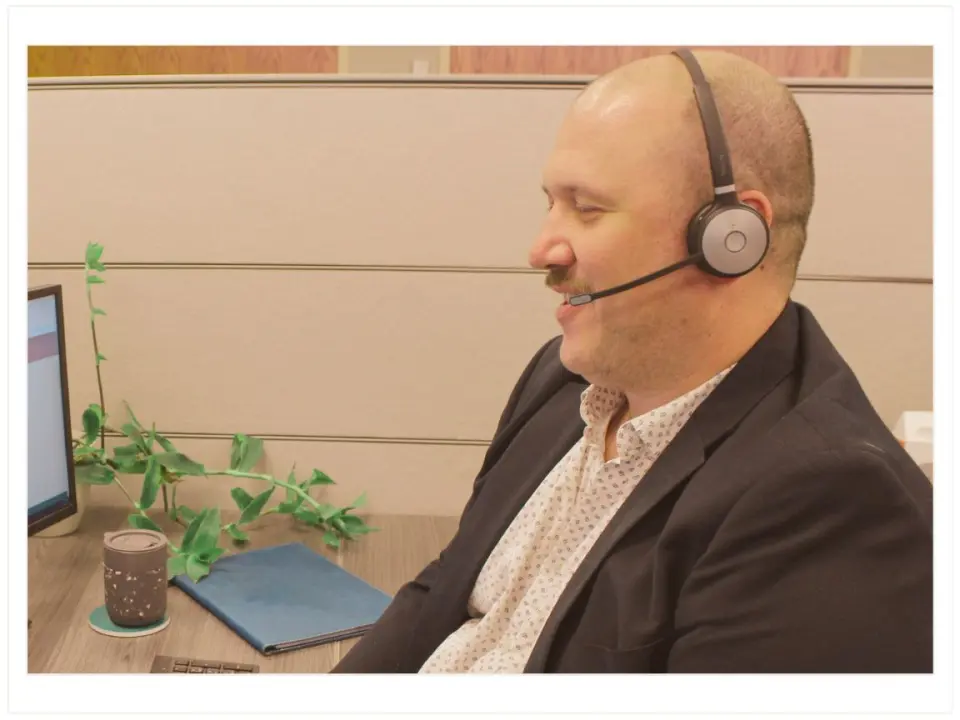 Partner and Vice President Marc Gilker of Journey Search Partners wearing a headset and sitting at a desk working