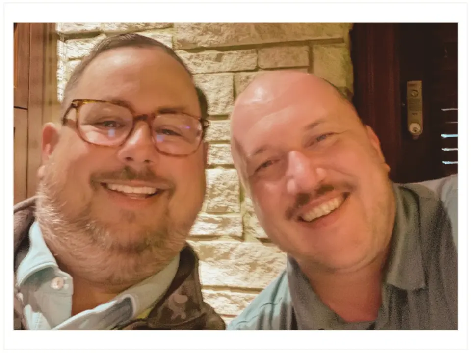 Owner, President, and CEO Casey Kraus and Partner and Vice President Marc Gilker of Journey Search Partners standing side by side outdoors with trees in the background