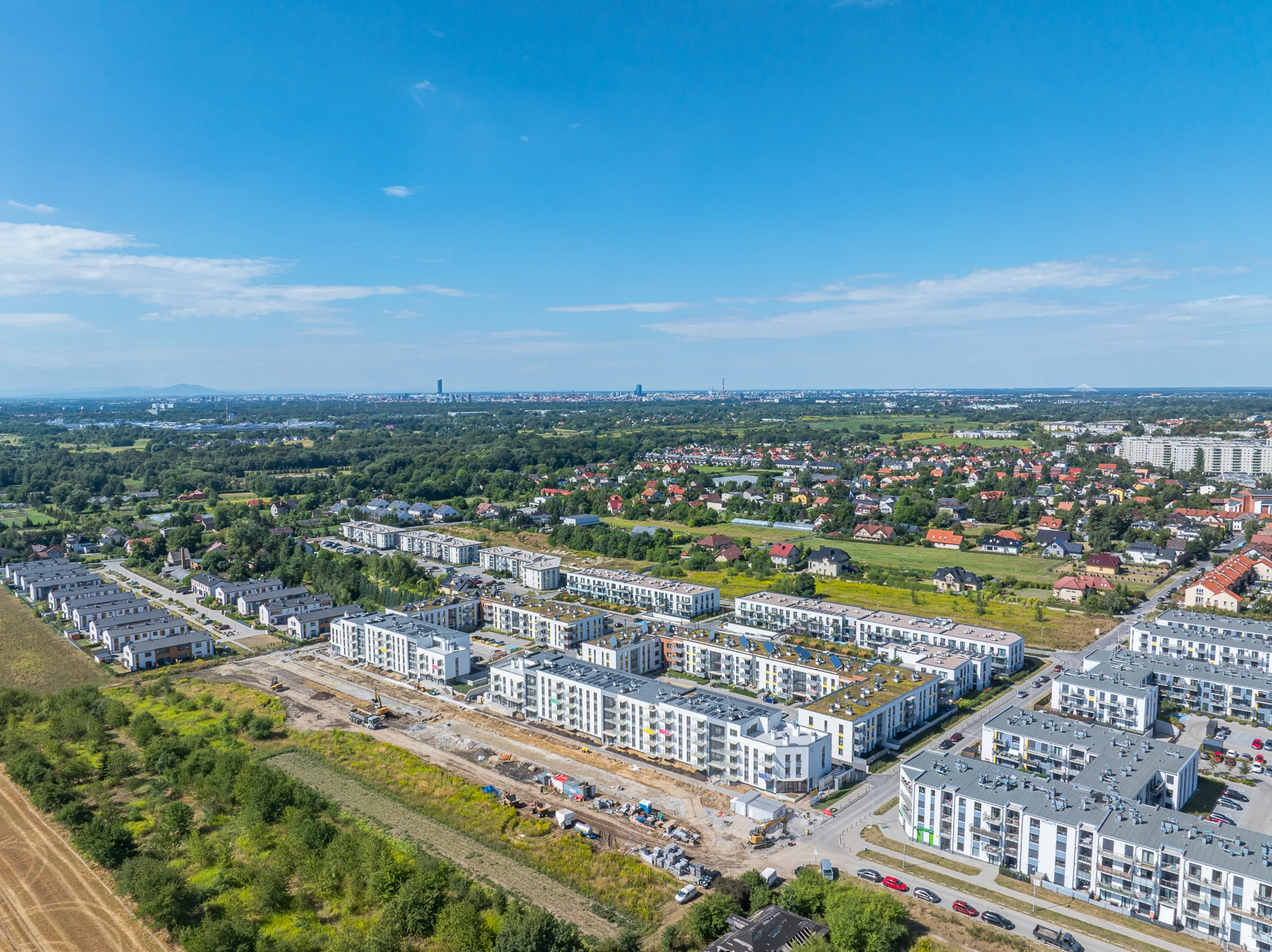 Osiedle Latawców z lotu ptaka — sierpień 2026, w tle panorama Wrocławia