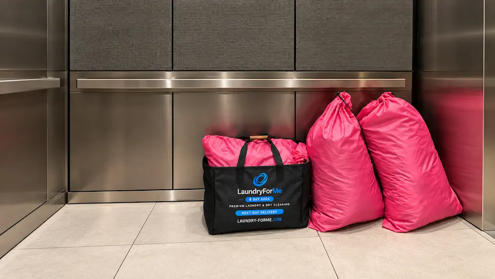 Real pink customer laundry bags beside a finished LaundryForMe return bag