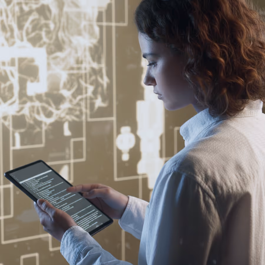 Woman with curly hair holds a tablet displaying code against a background of abstract tech graphics.