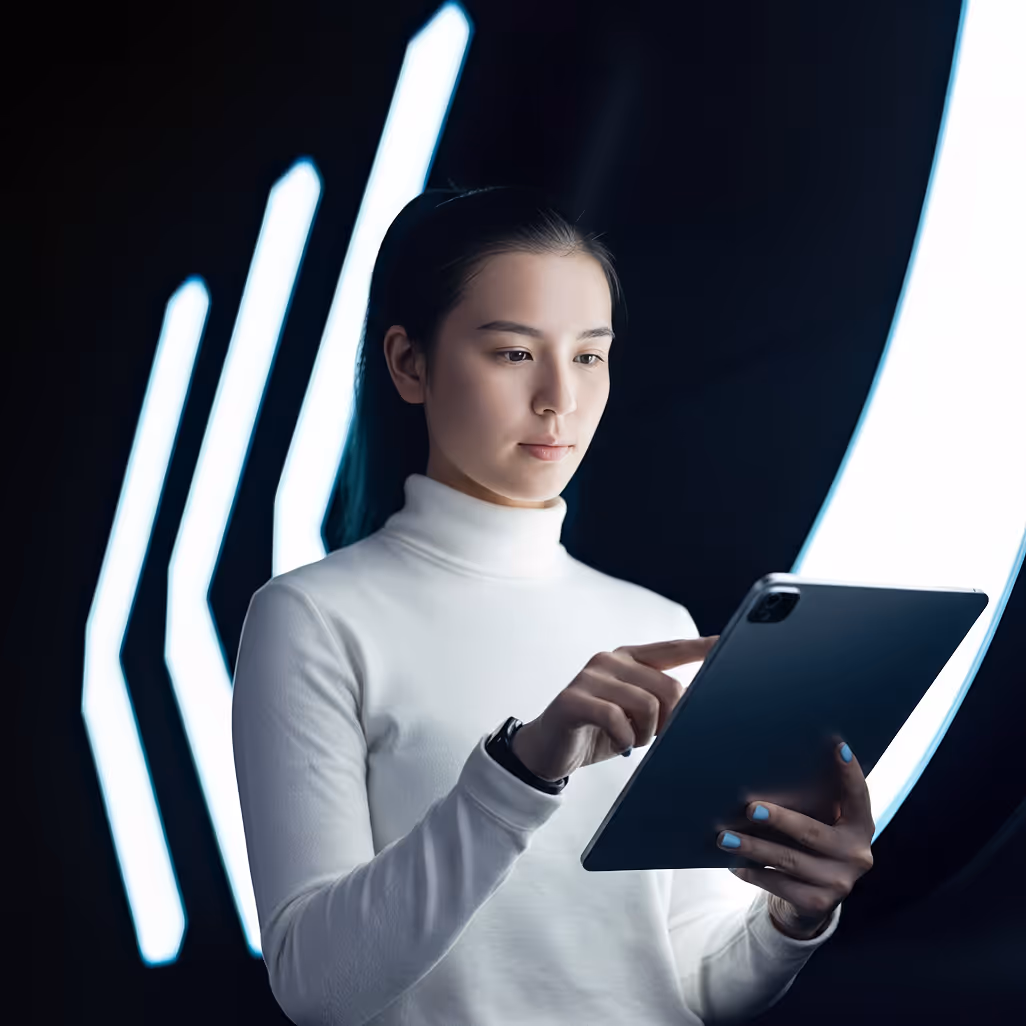 Young woman in a white turtleneck using a tablet with futuristic light strips in the background.