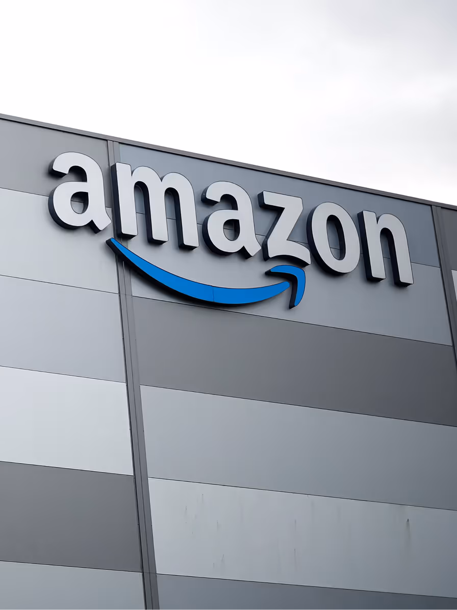 Amazon logo with a blue arrow sign on the exterior wall of a building.