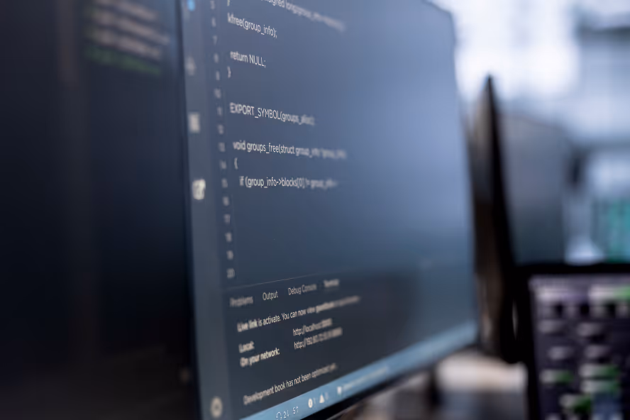 Close-up of a computer monitor displaying blurred programming code and terminal output.