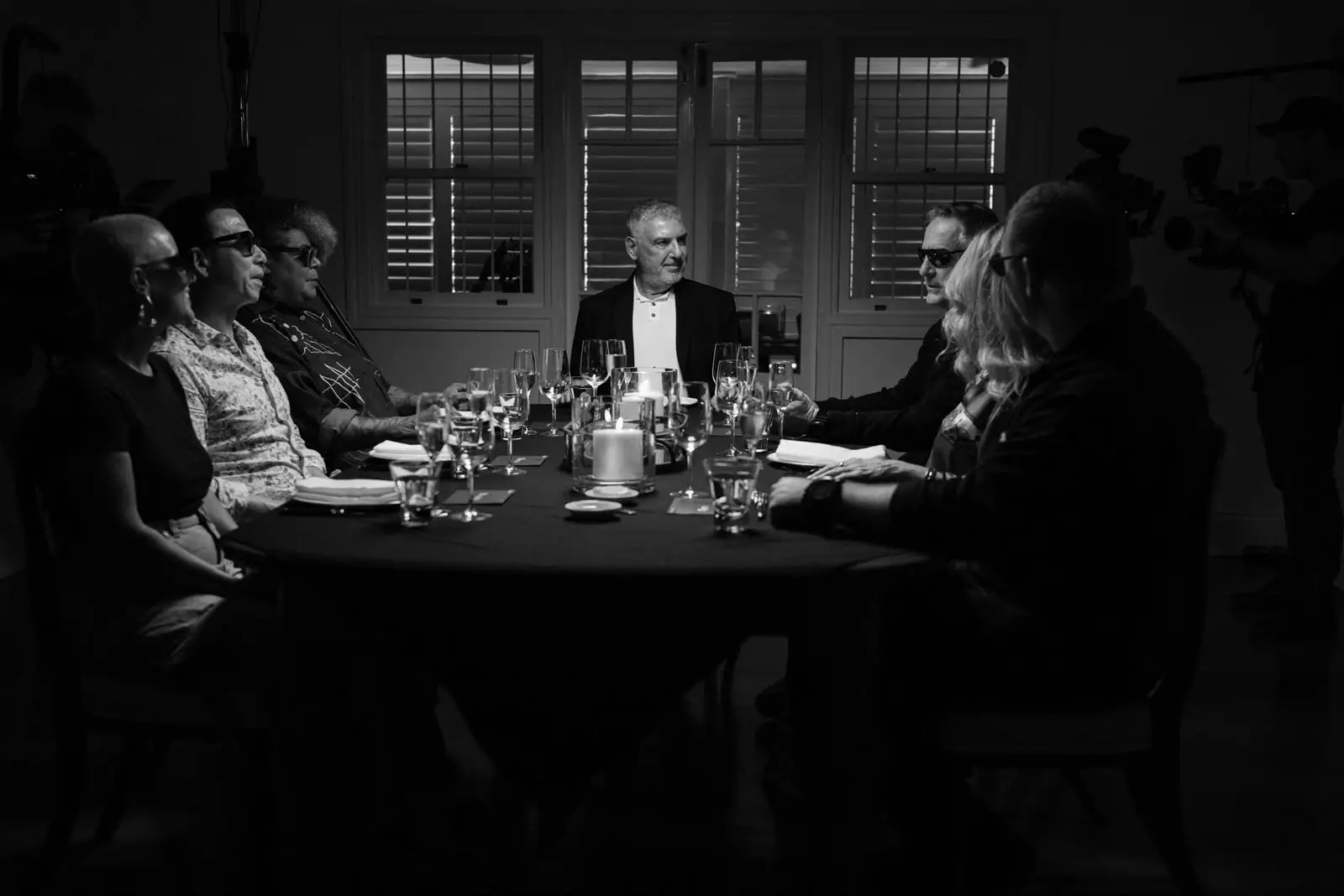 Black-and-white photo of guests at The Seventh Seat dinner table.
