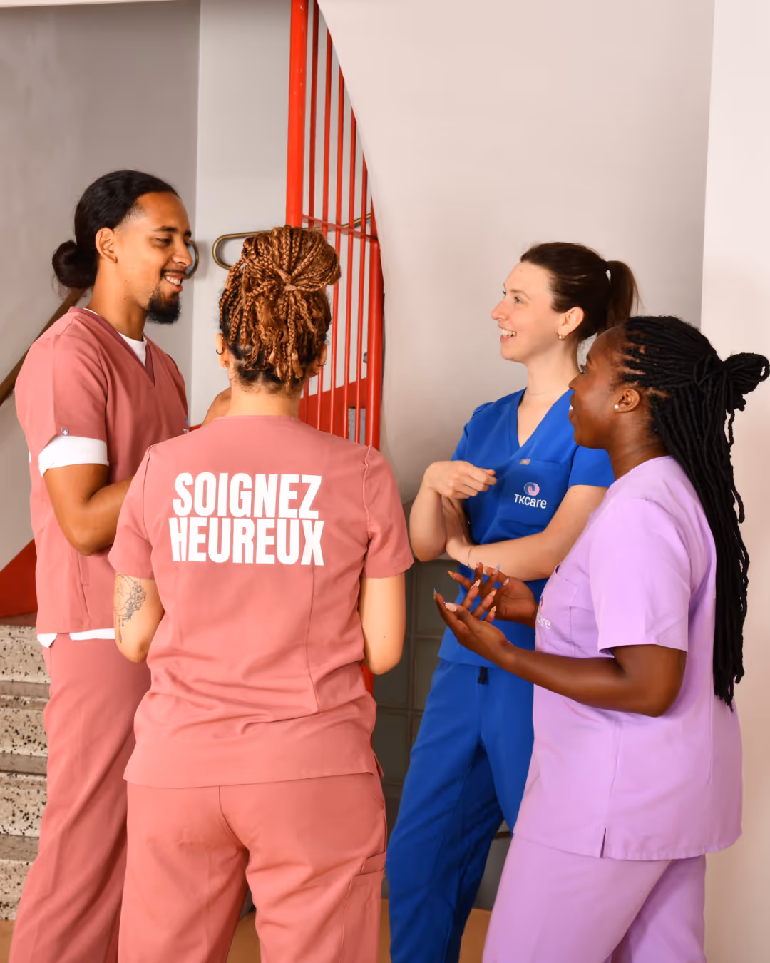 soignants en blouse. Sur l'une des blouses est écrit "soignez heureux"