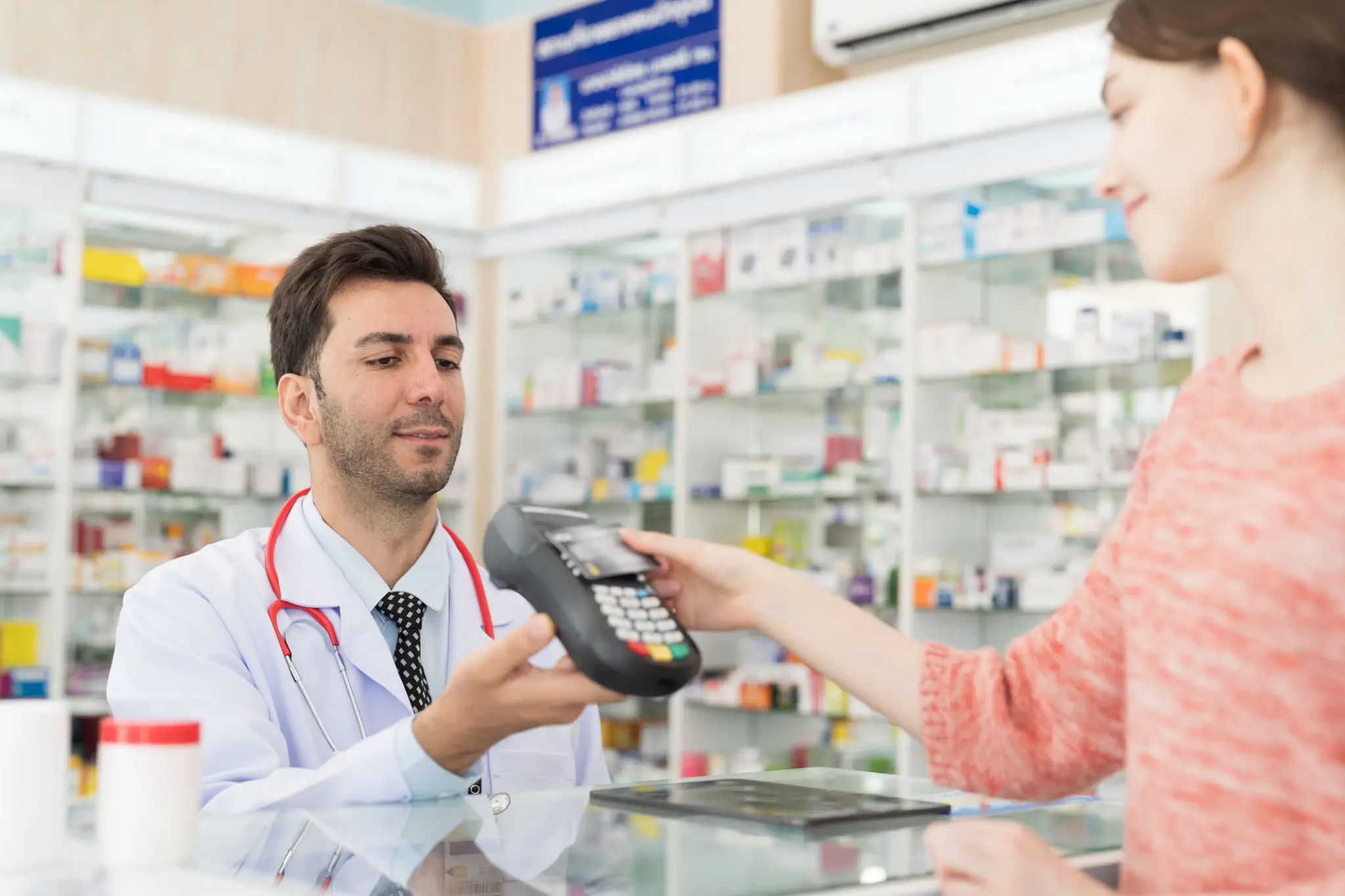 Pharmacist assisting a member at the pharmacy counter