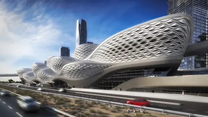 Modern, wavy architectural building alongside a city road with cars in motion.