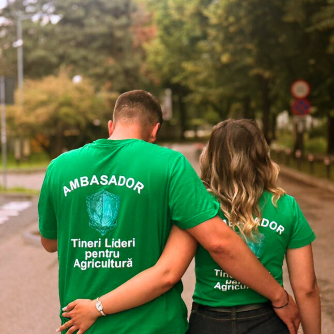 Doi absolventi Tineri Lideri pentru Agricultură care se țin în brate de la spate